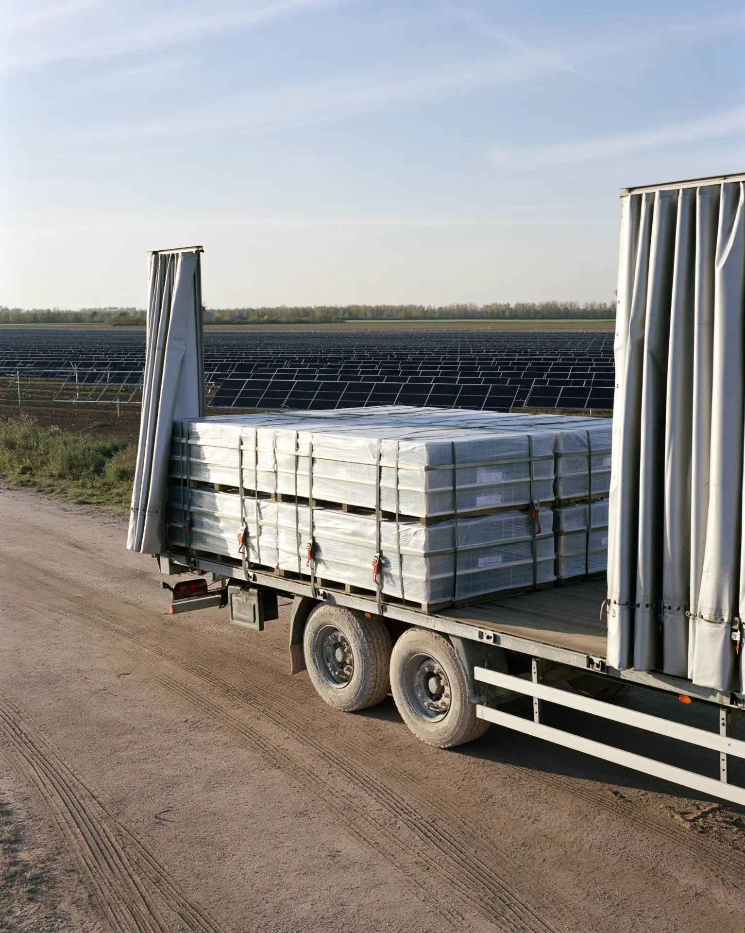LKW Lieferung mit palettierten PV Modulen am Solarpark